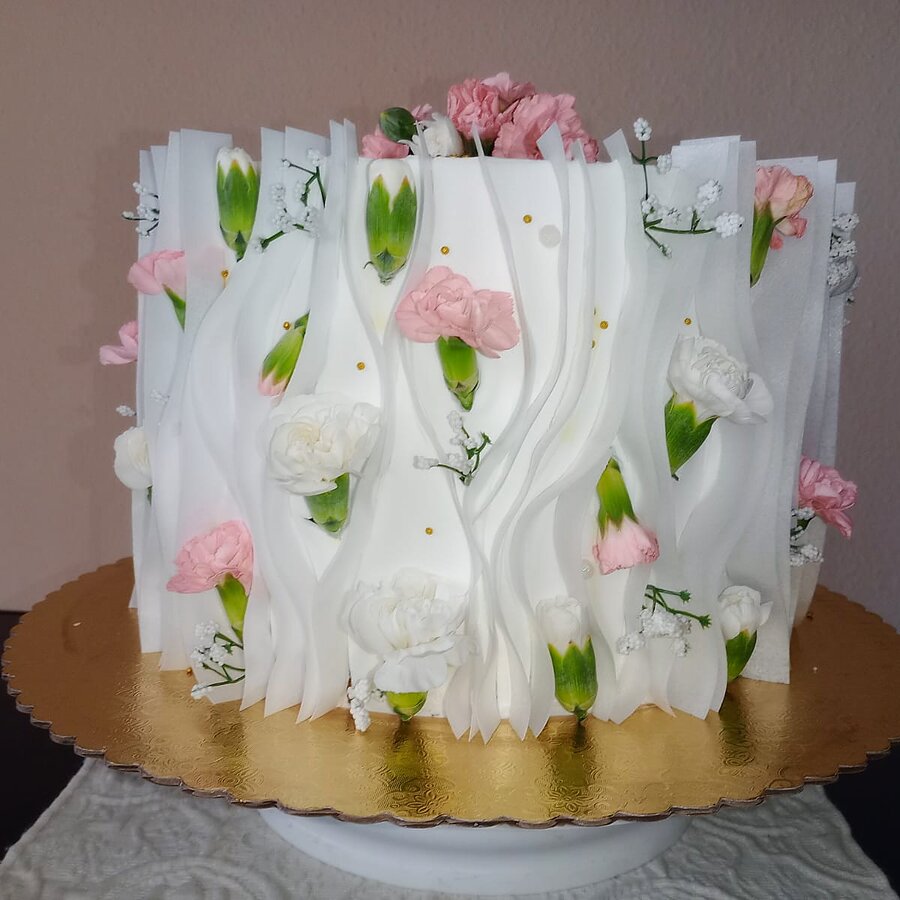 Pastel real blanco texturizado con flores rosadas