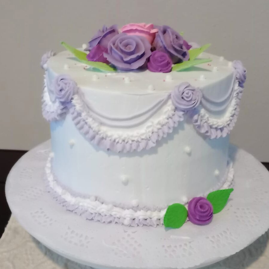 Pastel real de pisos blanco con encaje lila y rosas moradas